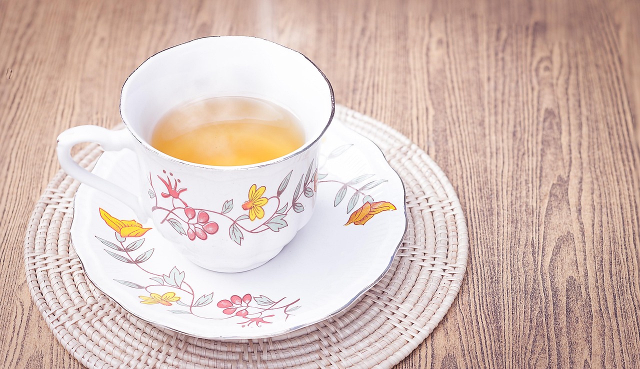 Tisana benefica per ridurre il gonfiore addominale, servita in una tazza su un tavolo festivo.