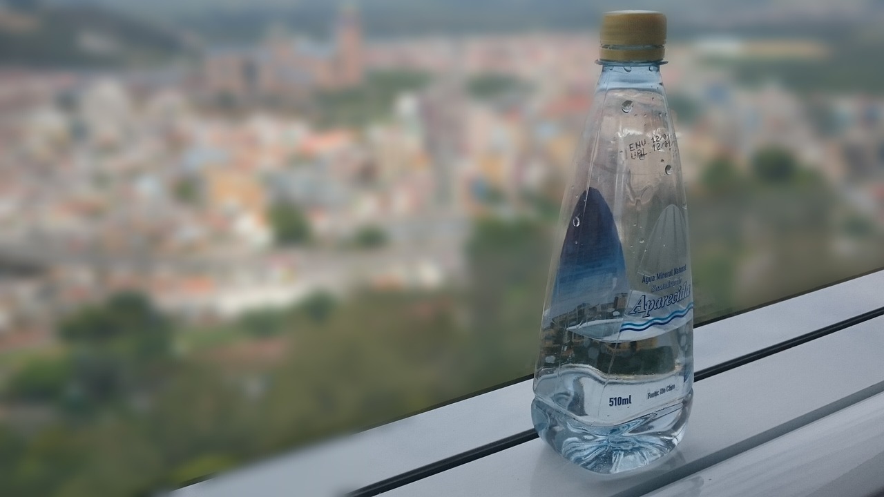 Bottiglie di acqua in plastica su uno sfondo, simbolo di consumo quotidiano sconsigliato.