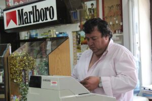 Immagine di un tabaccaio che mostra un Gratta e Vinci vincente con un sorriso soddisfatto.