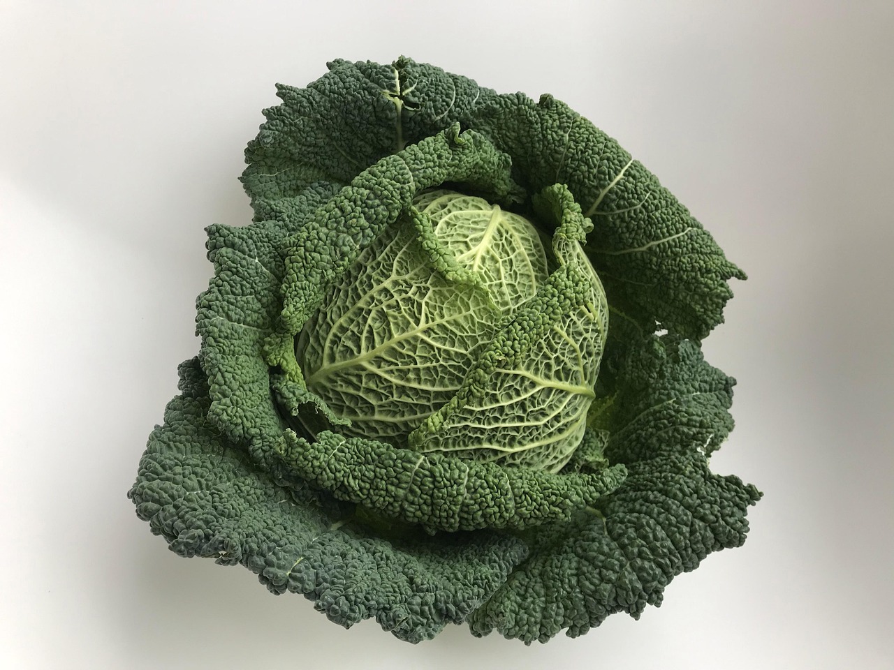 Cavolo nero fresco su un tagliere, pronto per essere cucinato secondo i consigli dello chef.
