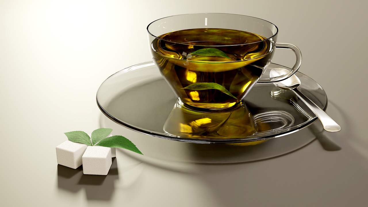 Tazza di tè verde fumante su un tavolo, simbolo di benessere per metabolismo e cuore.